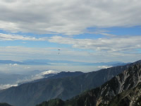 写真：山間を飛ぶ物資輸送のヘリコプター